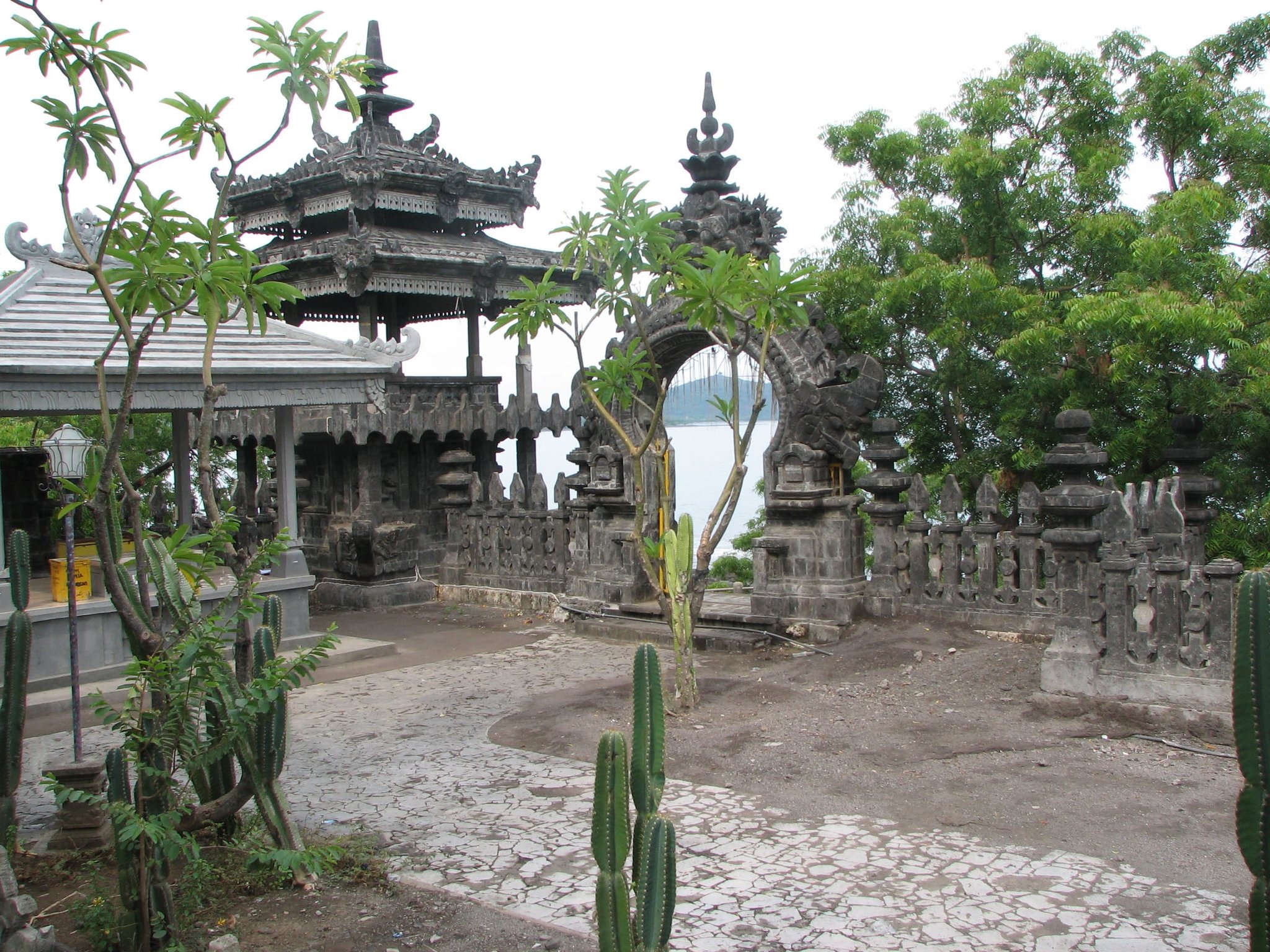The black stone gateway and pavilions of Pura Pulaki temple on the headland, with Pemuteran bay behind